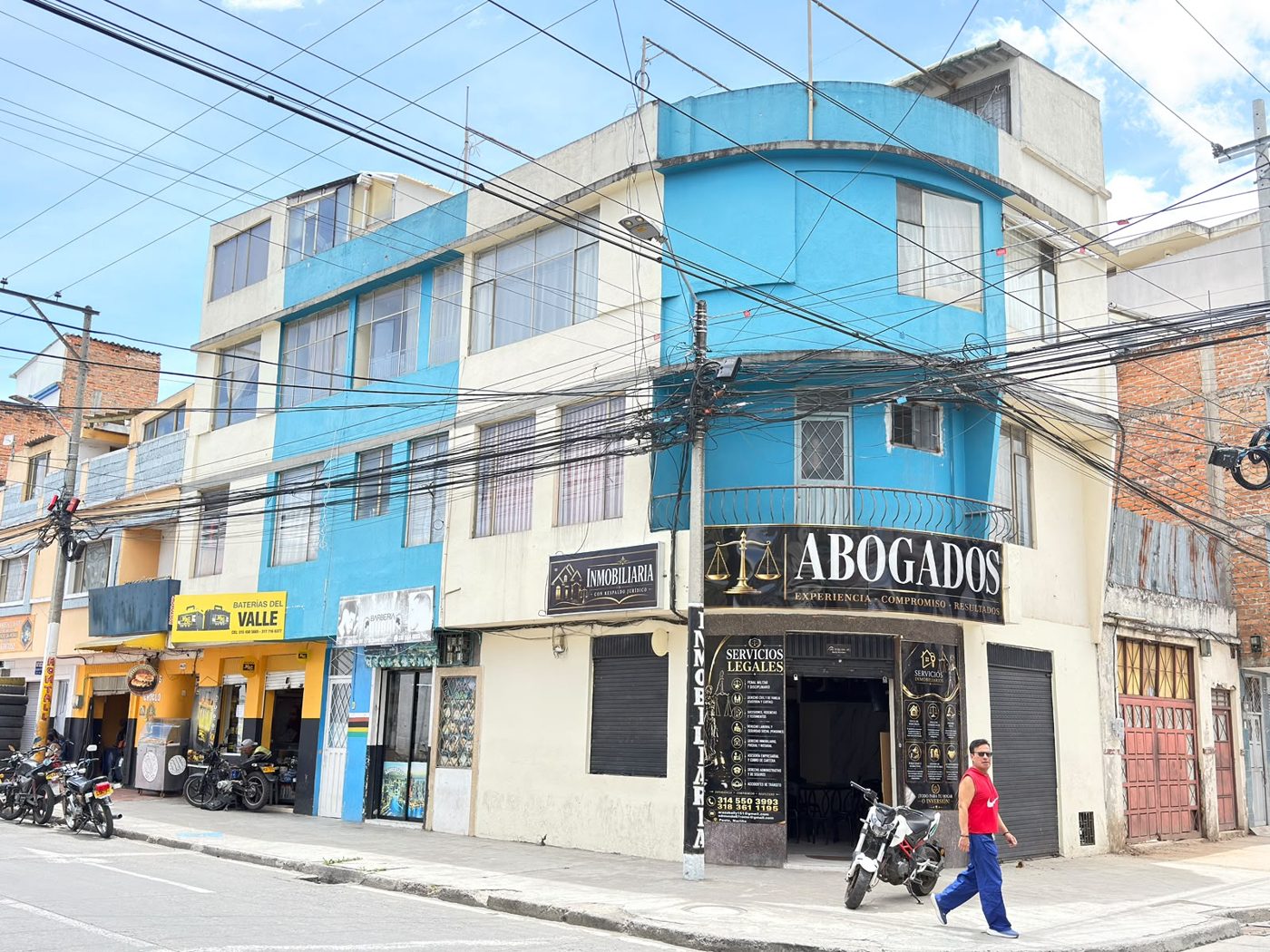 Fachada del edificio en la esquina, con los avisos de Abogados e Inmobiliaria